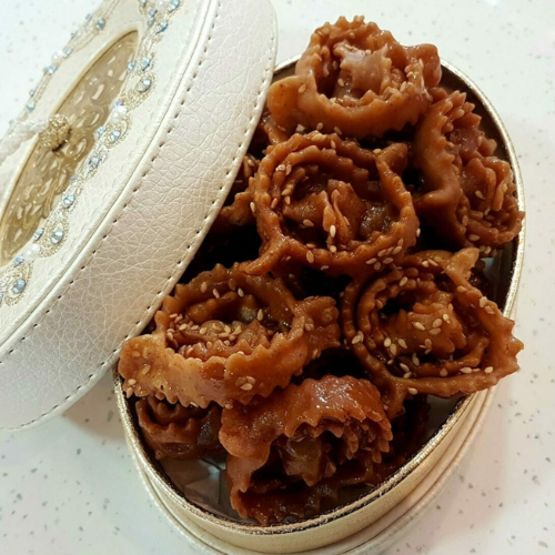 Chebakia marocaine dorée au miel et sésame, présentée dans une élégante boîte artisanale.